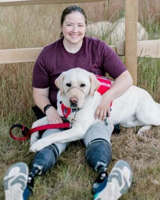 Rebecca Mann, Vice President and Veterans Advocate of MWD, sitting with a yellow dog